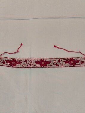 red beaded belt with a floral design